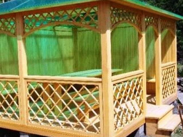 Классическая форма беседки – деревянные решетки и прозрачная крыша.