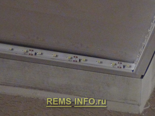 Монтаж светодиодной ленты подсветки в углах натяжного потолка.