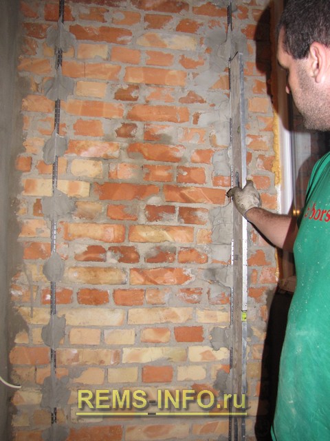 Штукатурка стен - контрольный замер полученной плоскости по выставленным маякам с помощью пузырькового уровня.